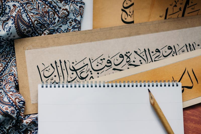 Arabic calligraphy with notepad and pen