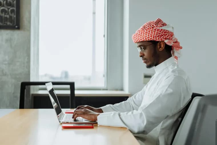 Middle Eastern professional working at a modern office desk in Saudi Arabia