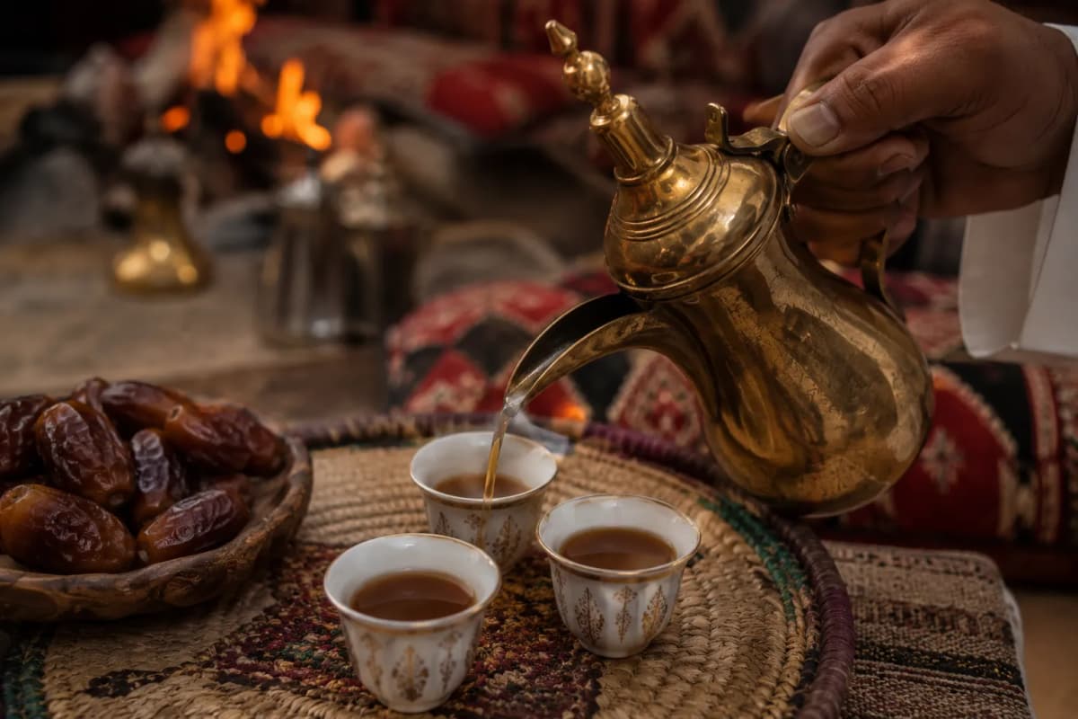 Arabic coffee poured from a dallah into traditional cups, with dates