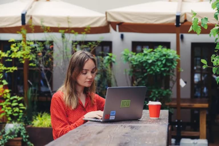 Digital nomad working on laptop in a cafe