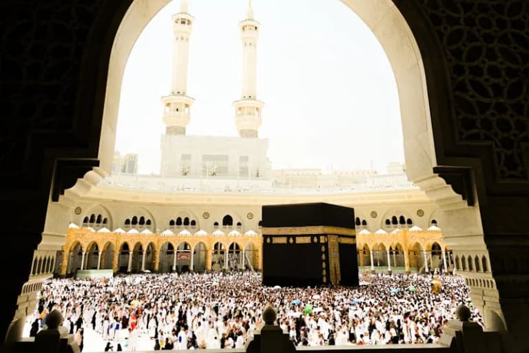 Large crowd of pilgrims performing Tawaf around the Kaaba during daylight