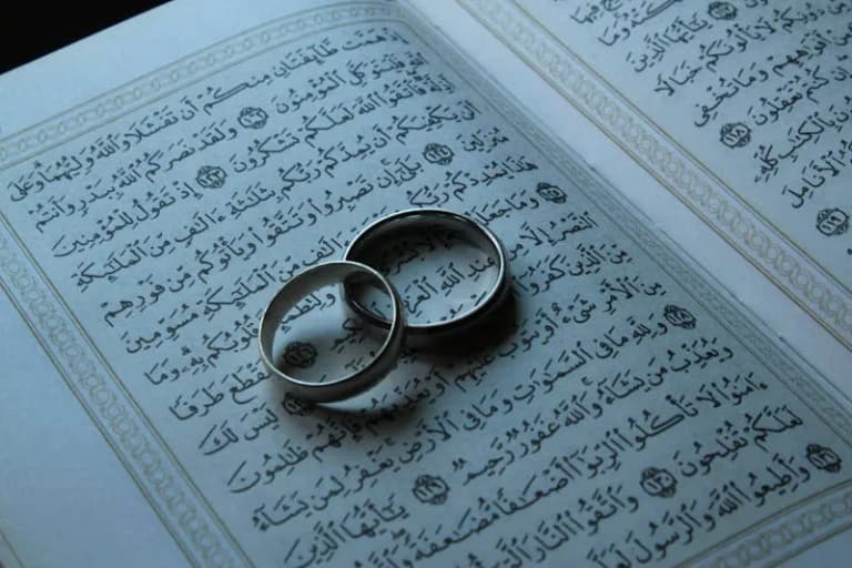 Wedding rings on an open Quran page