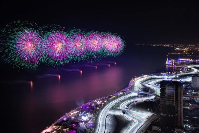 Spectacular fireworks display illuminating a waterfront city skyline at night