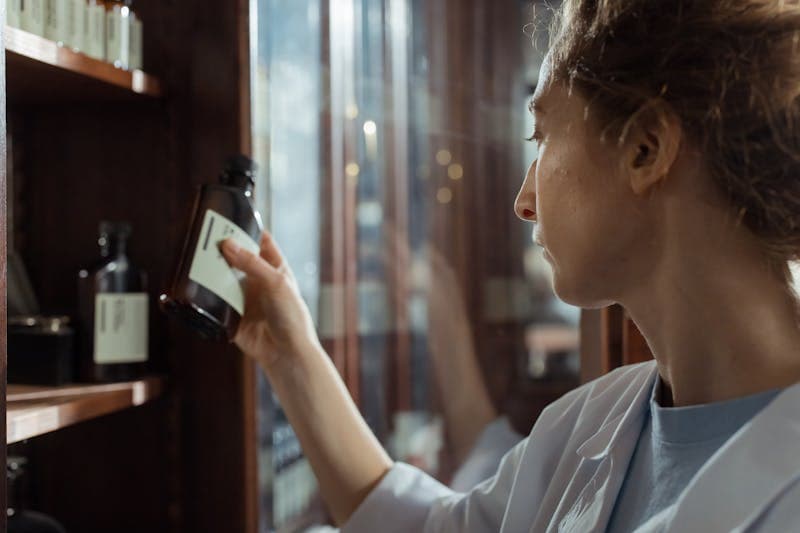 Pharmacist selecting medication from pharmacy shelves